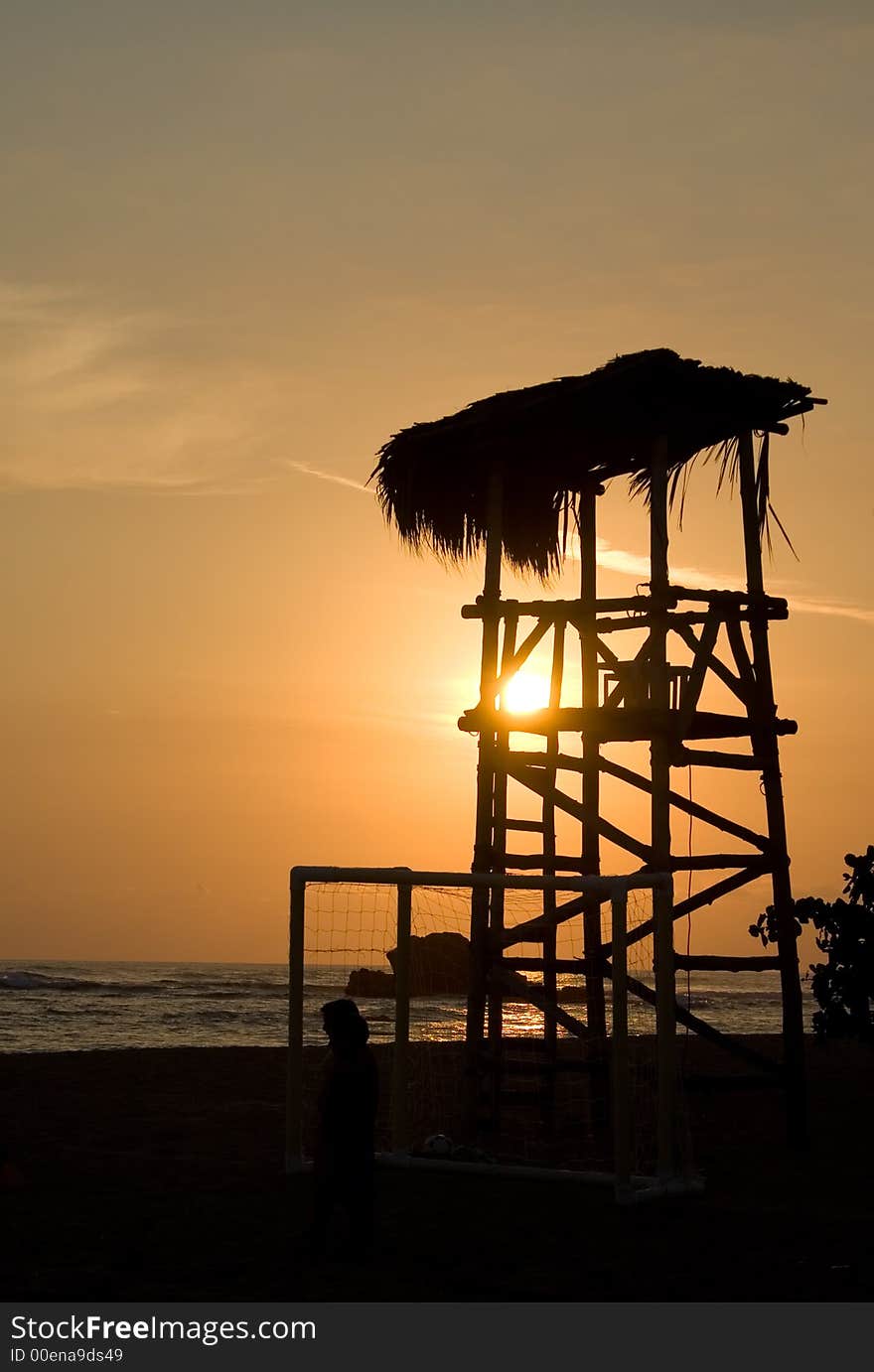 Silhouette of a beach lifeguard tower during sunset