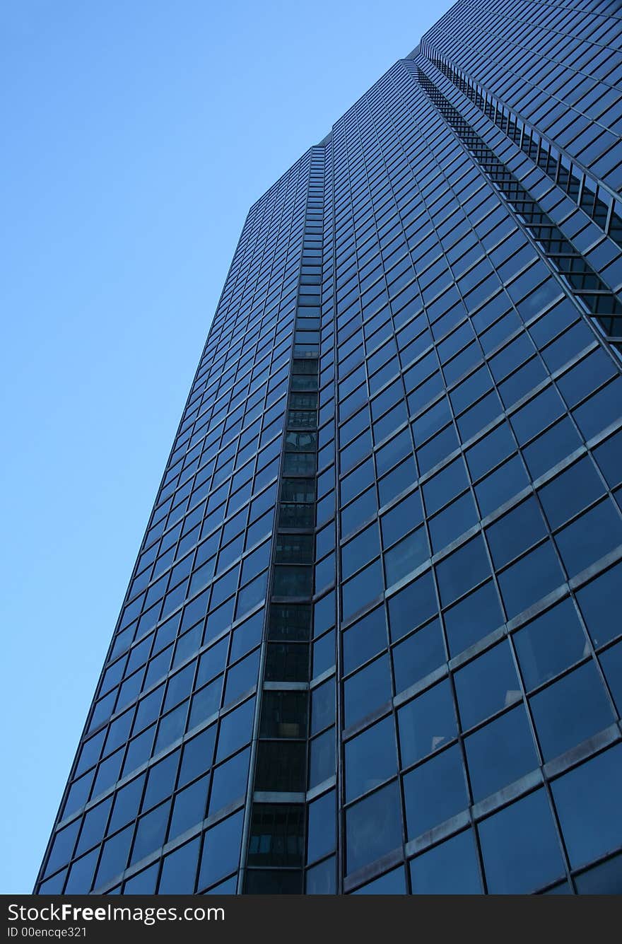 Perspective view of a blue glass-windowed skyscraper.