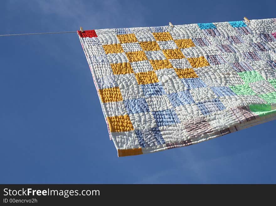 Laundry - bright counterpane hanging to dry on a clothes-line.