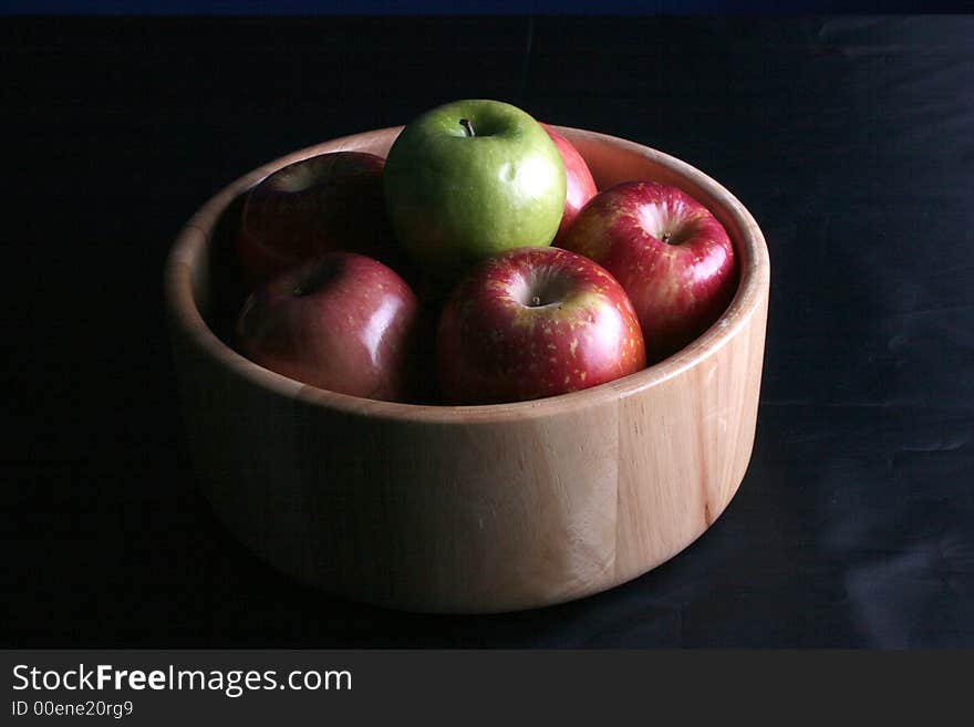 A bowl of healthy apples in low key lighting. A bowl of healthy apples in low key lighting.