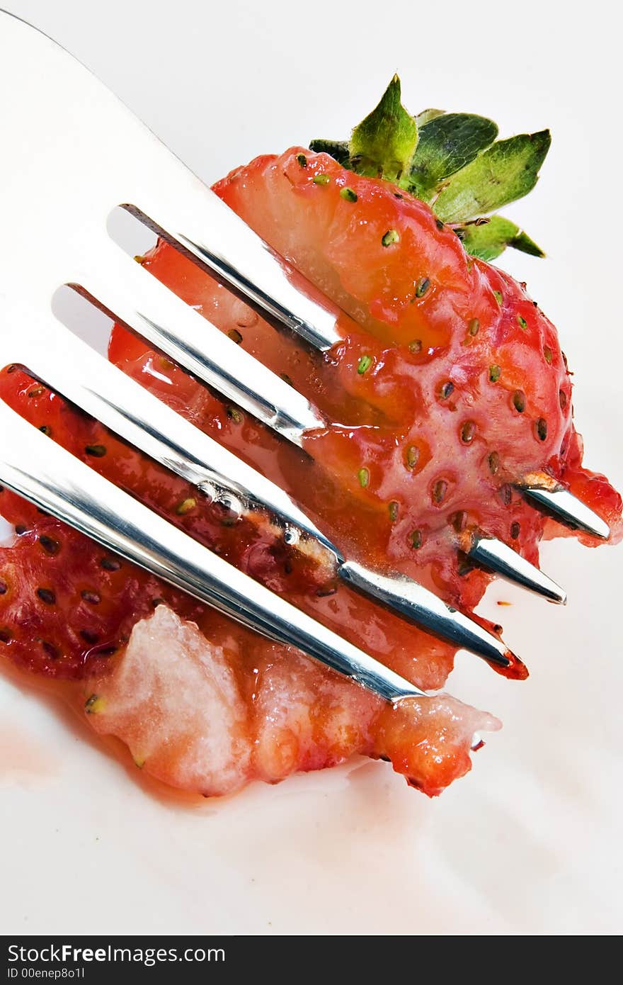 Strawberry being smashed by a fork. Strawberry being smashed by a fork