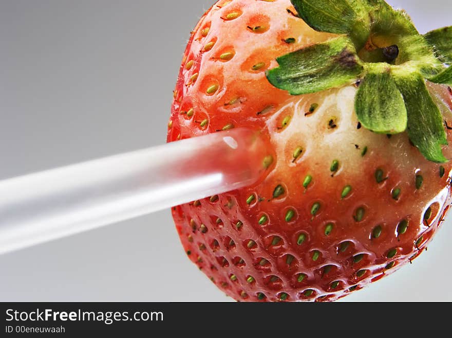 Strawberry with a straw stuck in it. Strawberry with a straw stuck in it