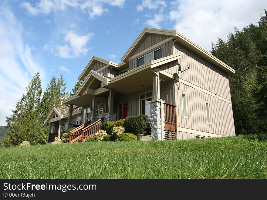 A lone new house with a green front lawn and beautifully decorated porch. A lone new house with a green front lawn and beautifully decorated porch.