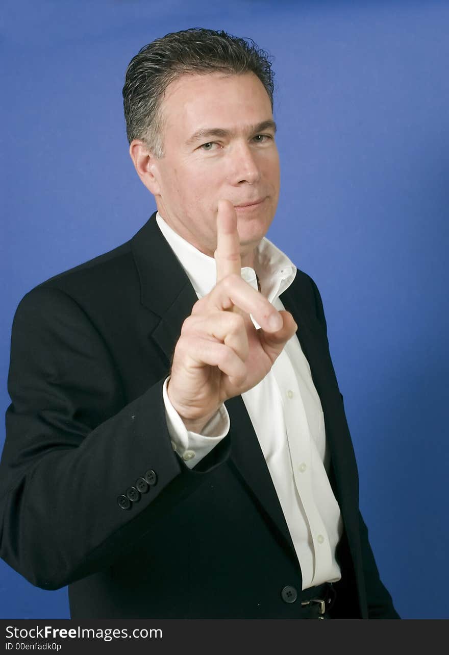 Handsome, mature, white male wearing a black suite and a white shirt gesturing with his as if ready to launch into a discussion or disagreement. Handsome, mature, white male wearing a black suite and a white shirt gesturing with his as if ready to launch into a discussion or disagreement.