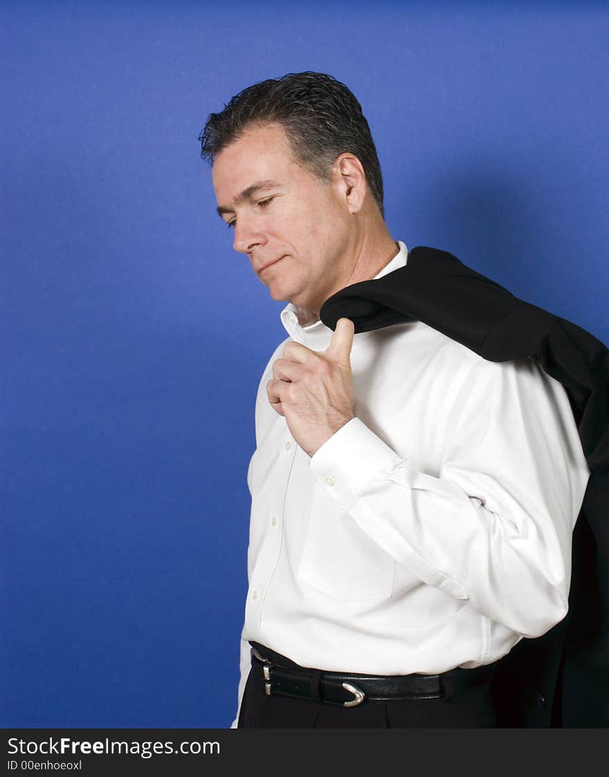 Man with his suit jacket flung over his shoulder with solemn body posture. Man with his suit jacket flung over his shoulder with solemn body posture.