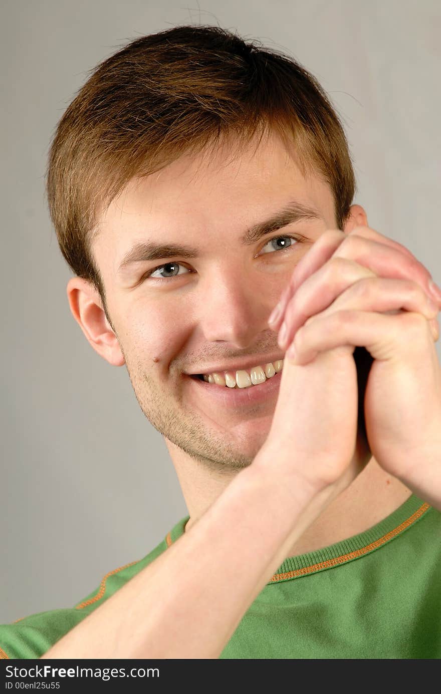 Portrait of  smiling young guy and  compressed hands,  close up. Portrait of  smiling young guy and  compressed hands,  close up