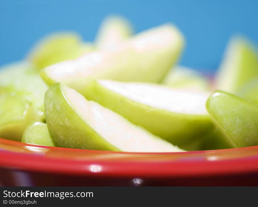 Juicy Sliced Apples against blue background.