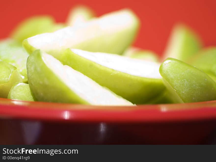 Juicy Sliced Apples against Red background.