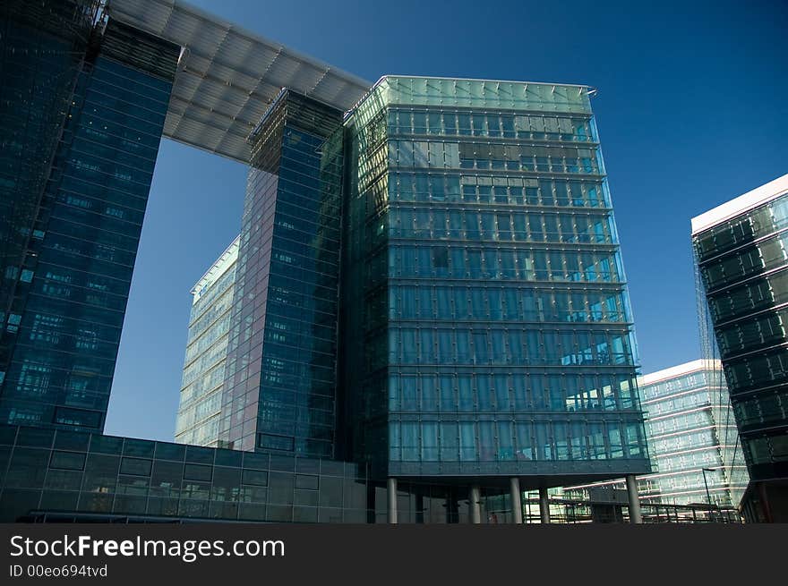 Business skyscrapers with windows fully made of glass mirroring sky and clouds, other skyscrapers and buildings.