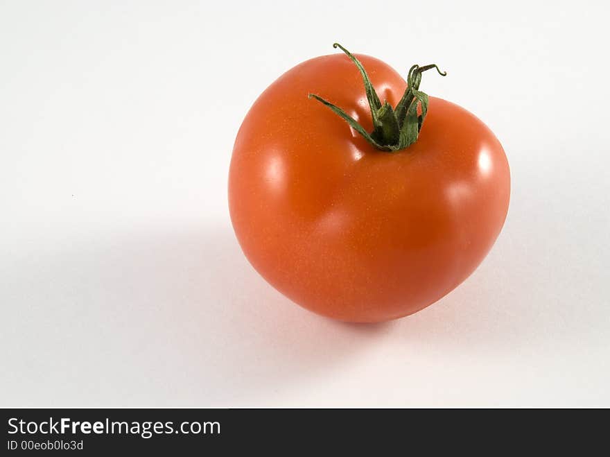 Single red tomato isolated on white background.