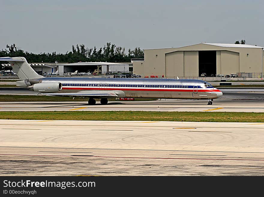 Large airliner taxiing down the runway at a busy airport. Large airliner taxiing down the runway at a busy airport