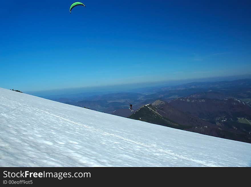 Man flying over snow with chute. Man flying over snow with chute