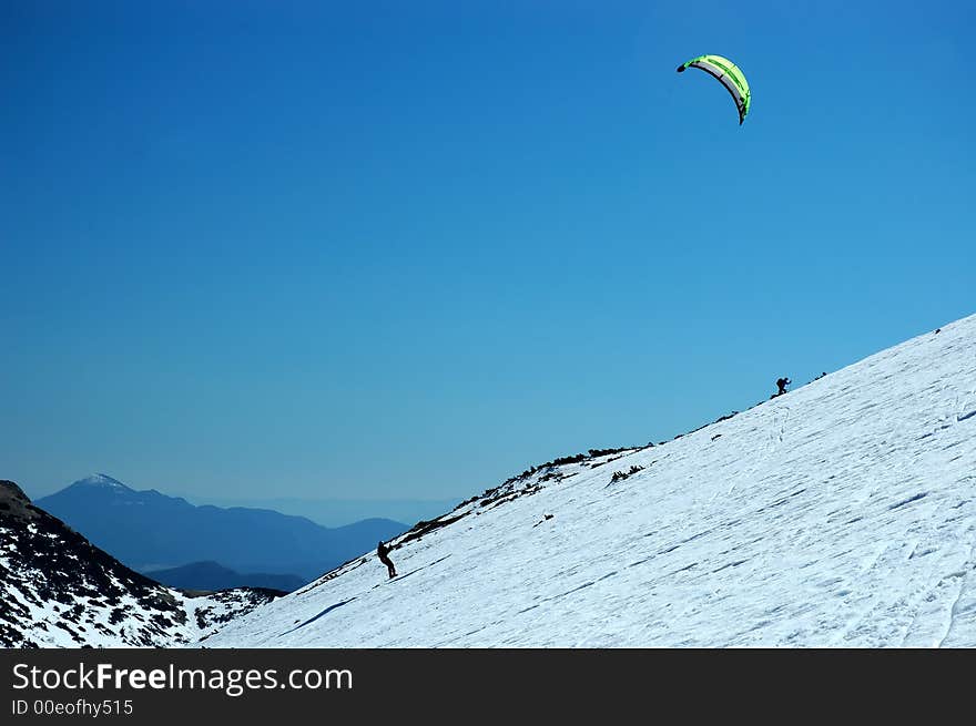 Skier with parachute pulling up the hill. Skier with parachute pulling up the hill