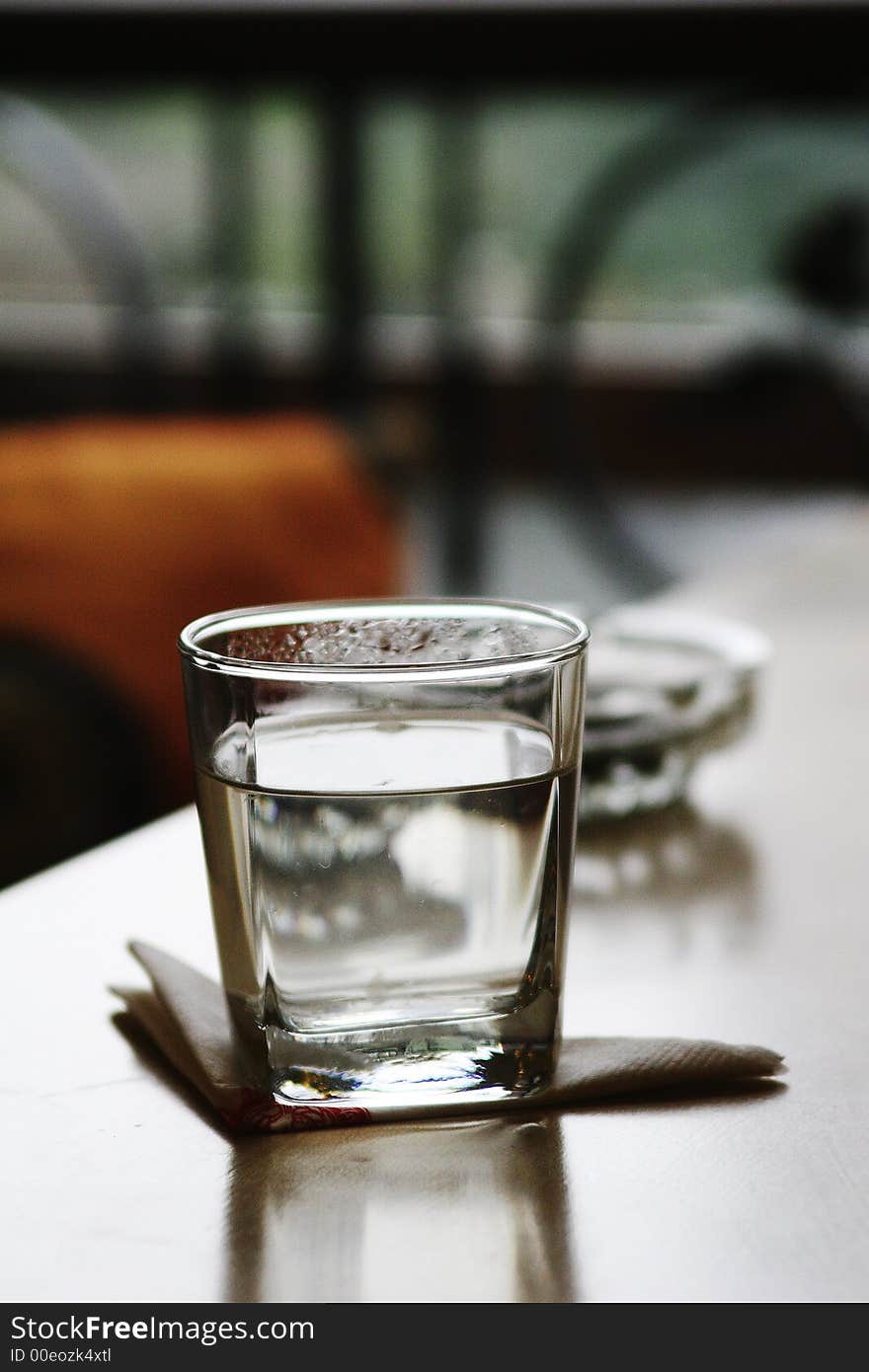 Glass and ashtray on table