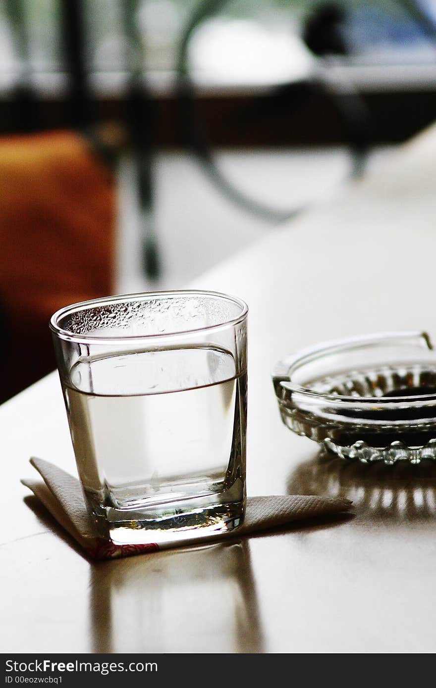 Glass and ashtray on table