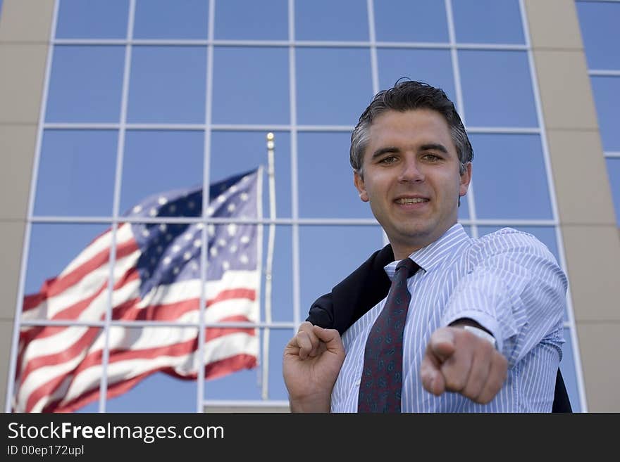 Businessman standing outside the office building with the American flag reflection in the windows. Businessman standing outside the office building with the American flag reflection in the windows