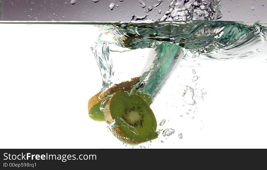 Kiwi slices splashing in water. Kiwi slices splashing in water