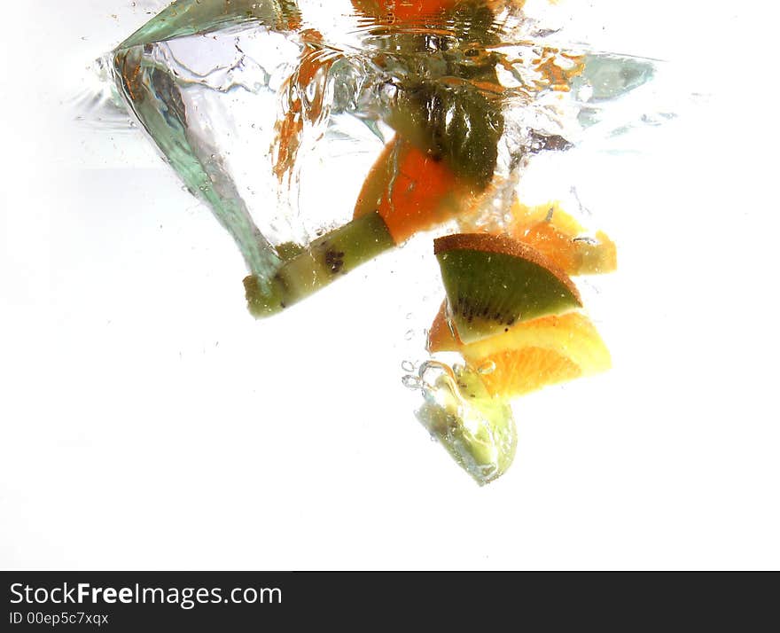 Kiwi and orange slices splashing in water. Kiwi and orange slices splashing in water