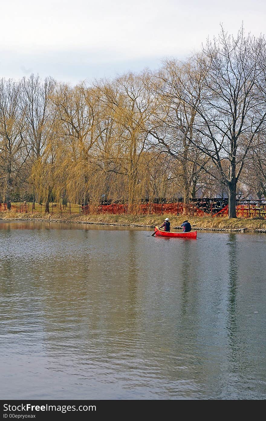 Two canoeists in a red canoe on a spring day at the Toronto (Ontario, Canada) Islands. Two canoeists in a red canoe on a spring day at the Toronto (Ontario, Canada) Islands.