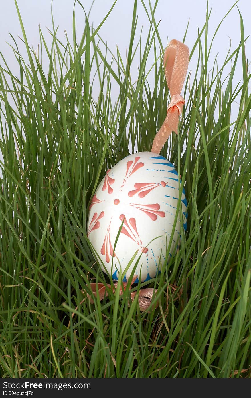 One easter egg with ribbon in grass. One easter egg with ribbon in grass