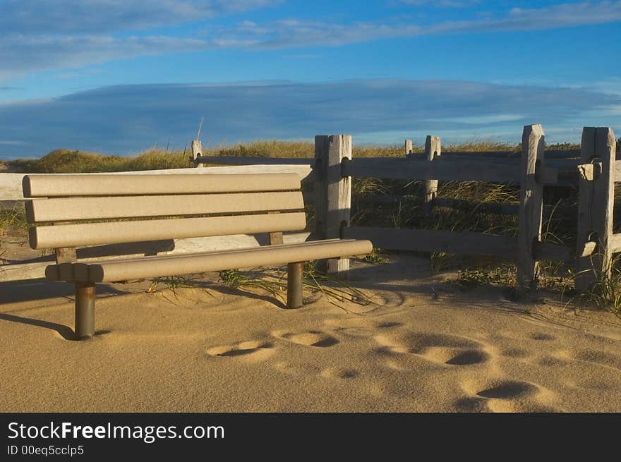 Empty park bench at sunrise in sand. Empty park bench at sunrise in sand