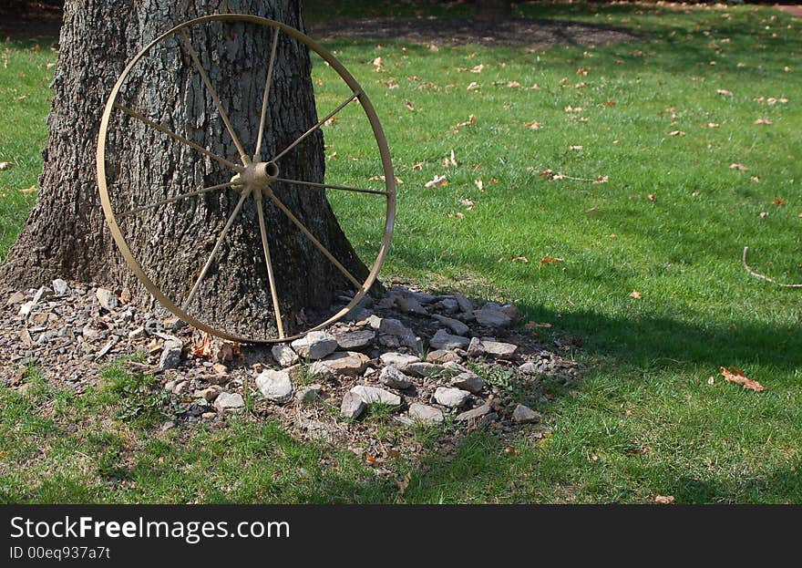 Old wagon wheel against a tree