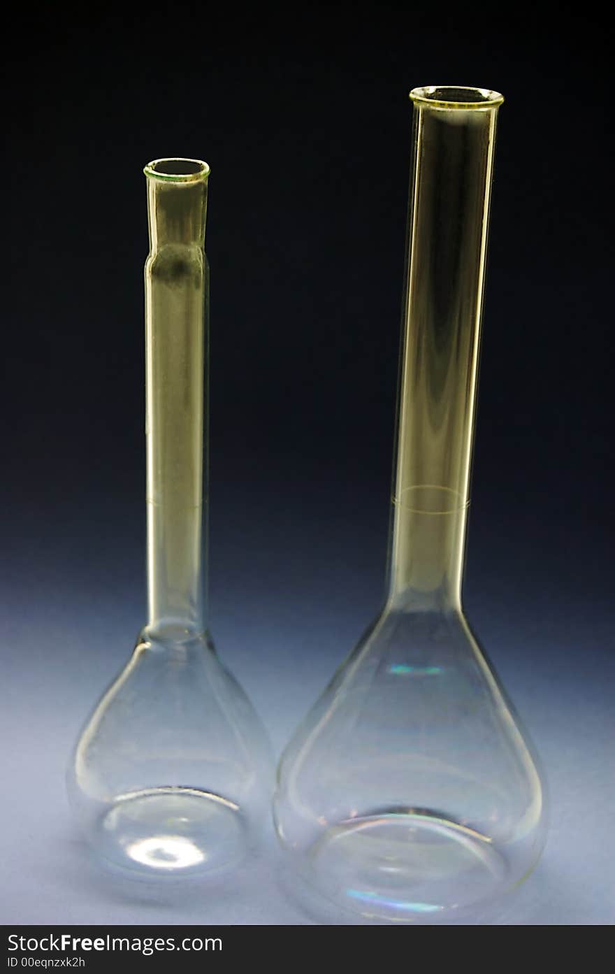 Two chemical tall flasks in a dark background. Two chemical tall flasks in a dark background