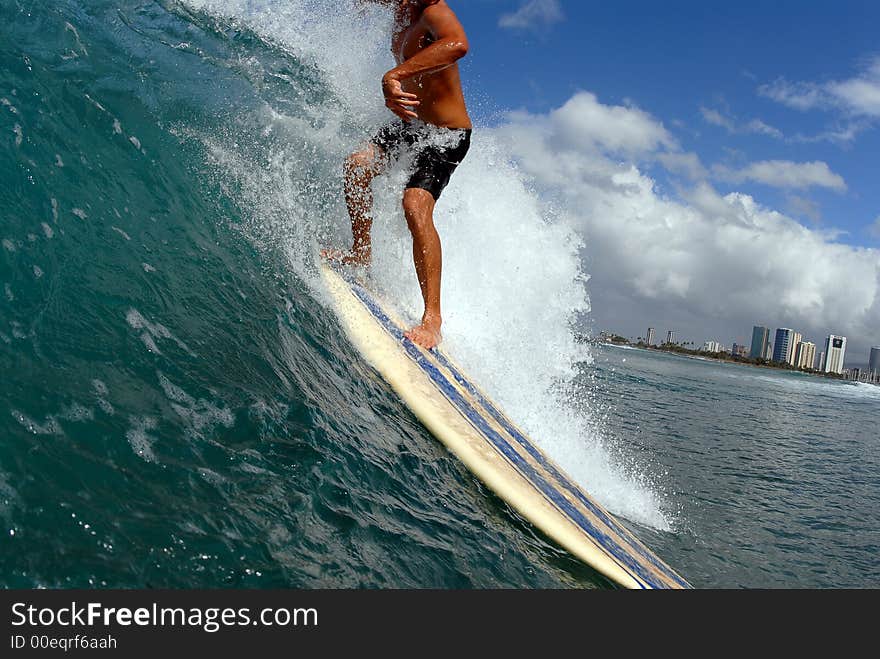 A longboard surfer taking off on a wave