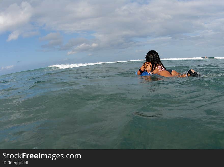 A bikini bodyboarder teen girl paddling out. A bikini bodyboarder teen girl paddling out