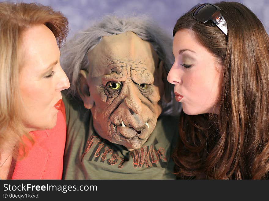 Shot of two gorgeous women kissing a monster