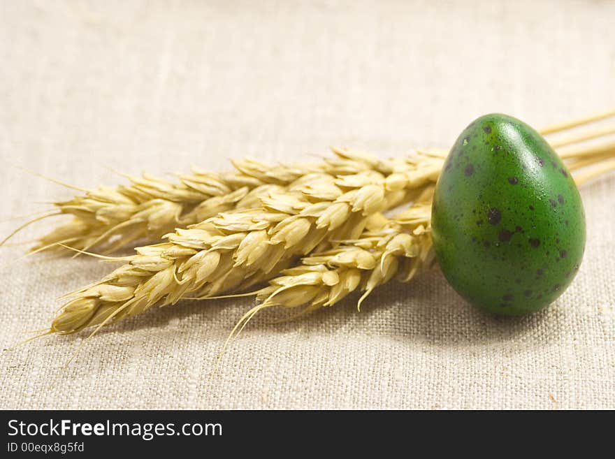 Wheat ears and green egg isolated