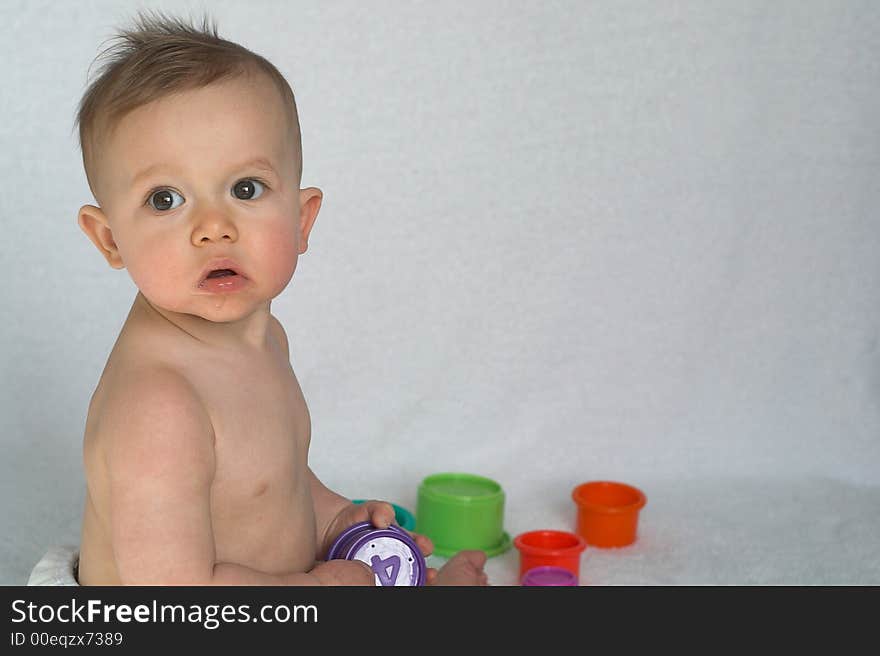 Image of adorable baby playing with stacking cups. Image of adorable baby playing with stacking cups