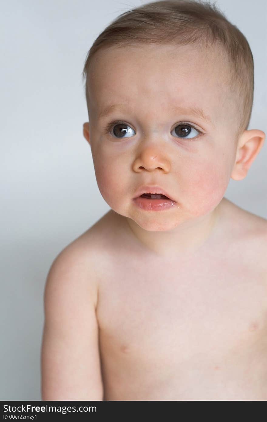 Image of beautiful 10 month old baby boy  sitting in front of a white background. Image of beautiful 10 month old baby boy  sitting in front of a white background