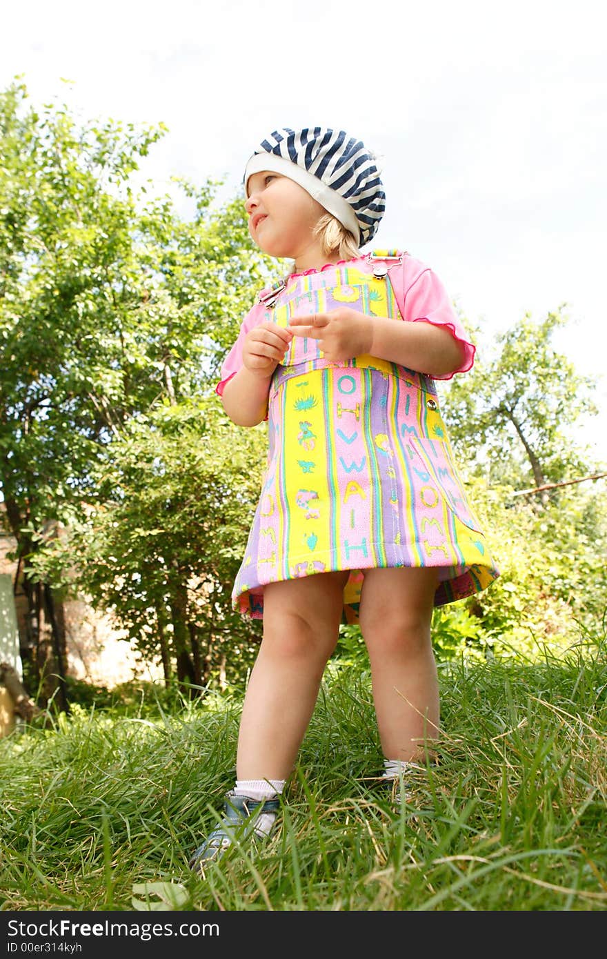 The girl stands on a grass and holds a ball in hands. The girl stands on a grass and holds a ball in hands