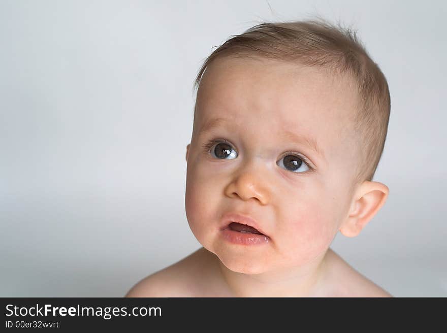 Image of beautiful 10 month old baby boy  sitting in front of a white background. Image of beautiful 10 month old baby boy  sitting in front of a white background