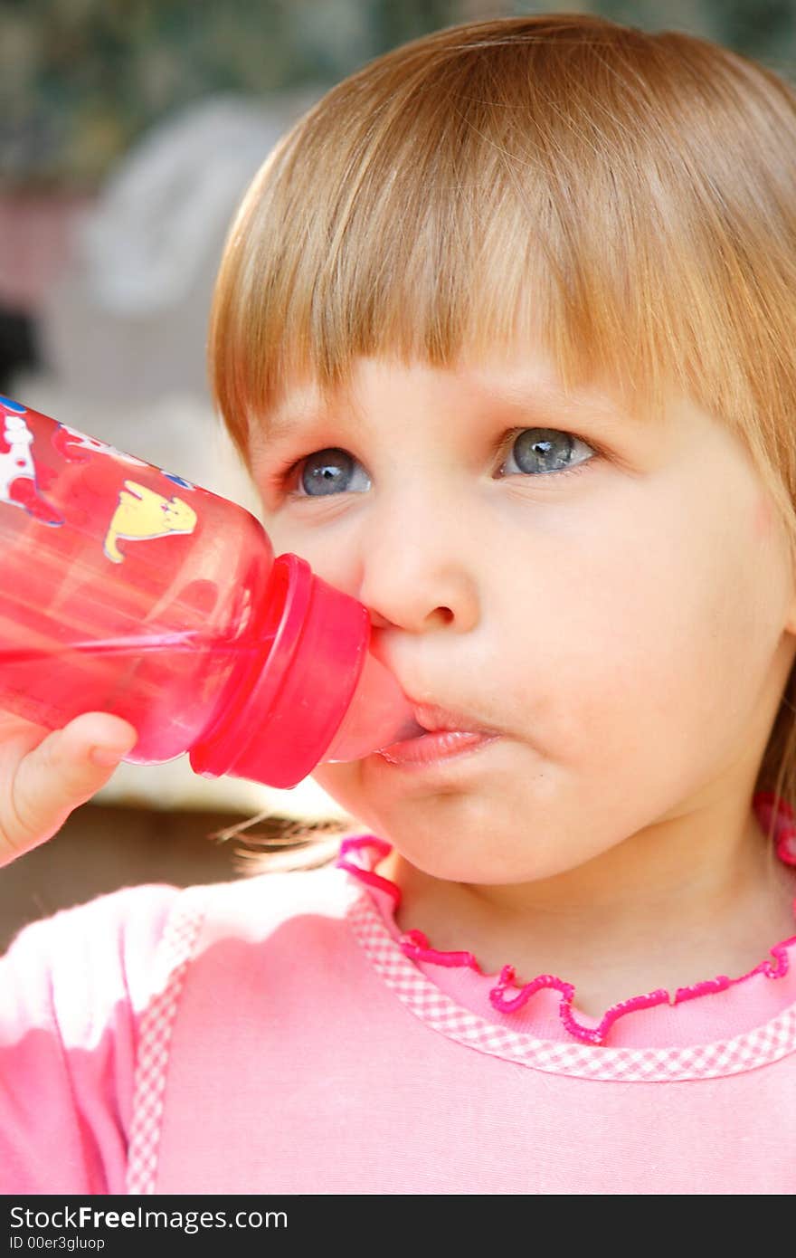 The girl drinks water from a bottle