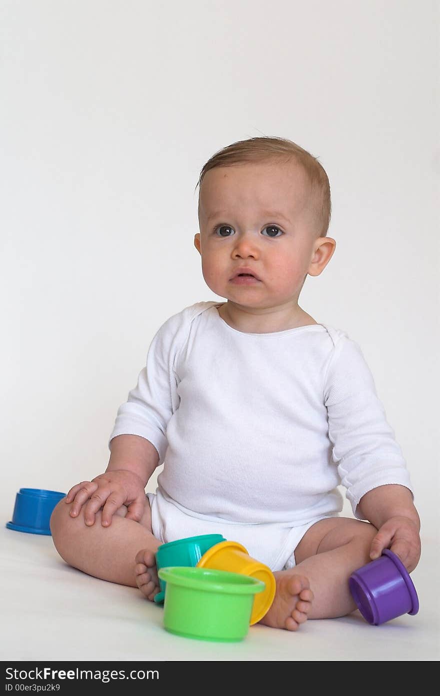 Image of adorable baby playing with stacking cups. Image of adorable baby playing with stacking cups