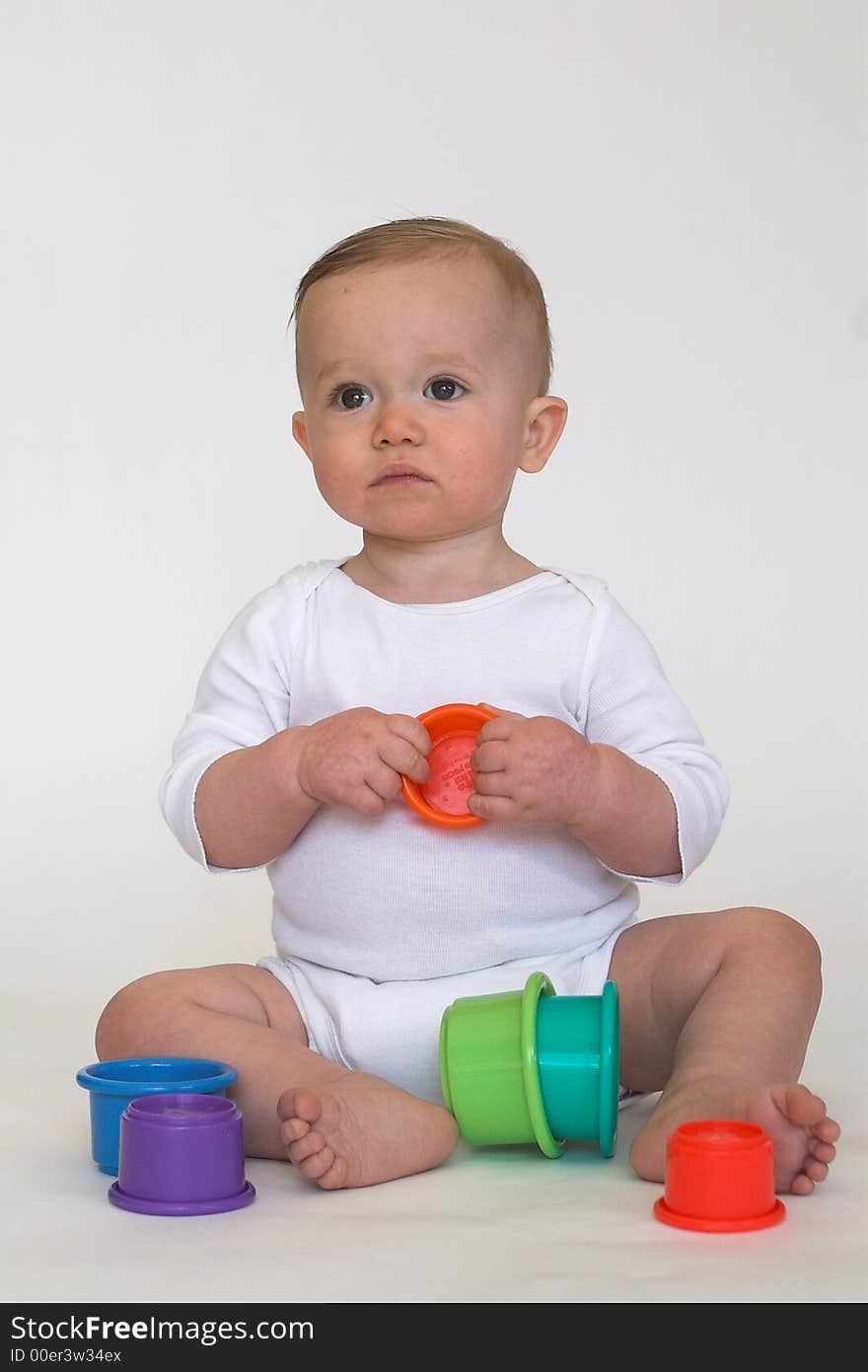 Image of adorable baby playing with stacking cups. Image of adorable baby playing with stacking cups