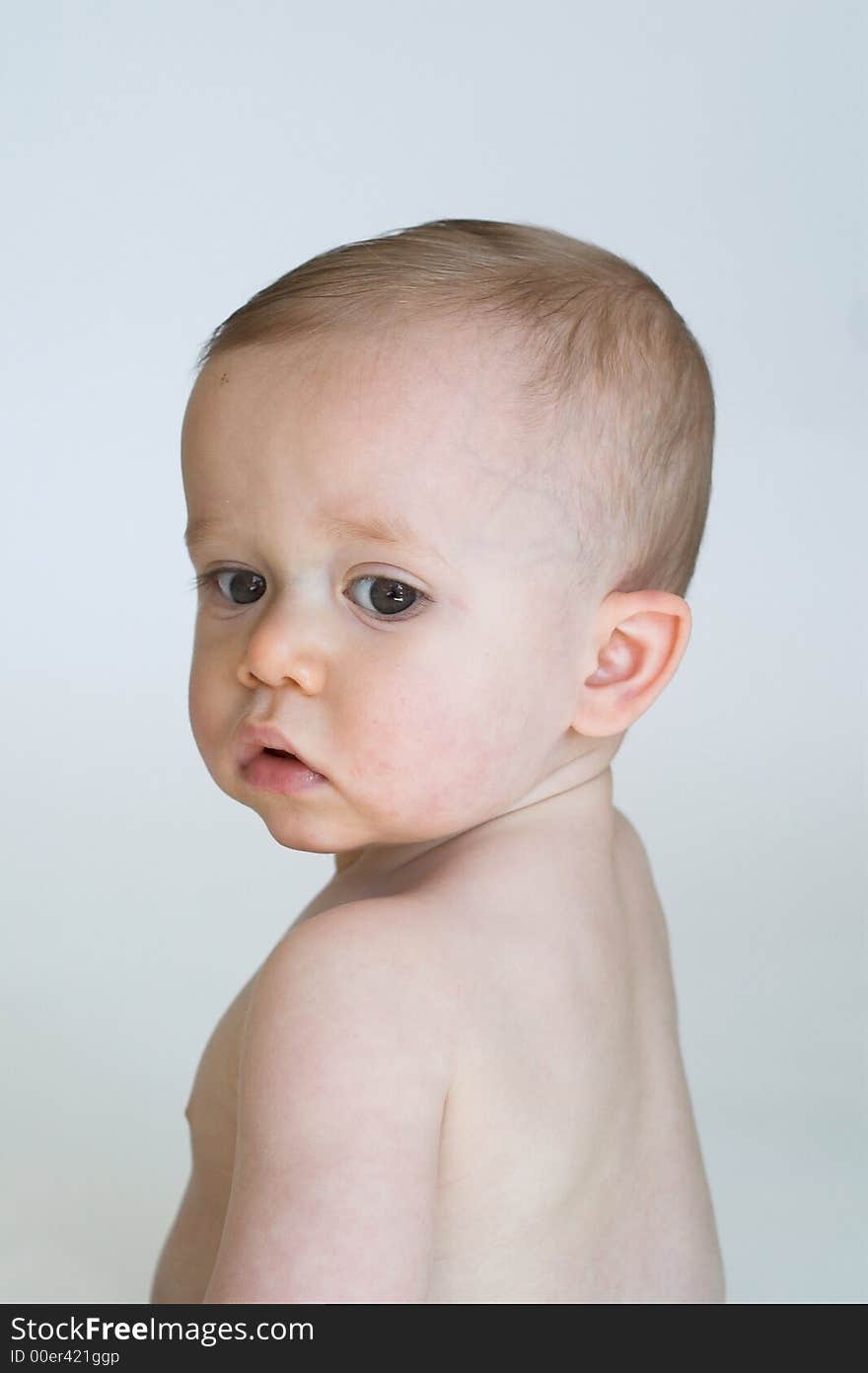 Image of beautiful 11 month old baby boy sitting in front of a white background. Image of beautiful 11 month old baby boy sitting in front of a white background