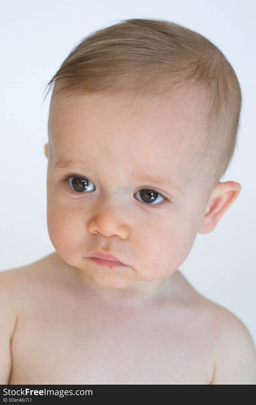 Image of beautiful 11 month old baby boy  sitting in front of a white background. Image of beautiful 11 month old baby boy  sitting in front of a white background