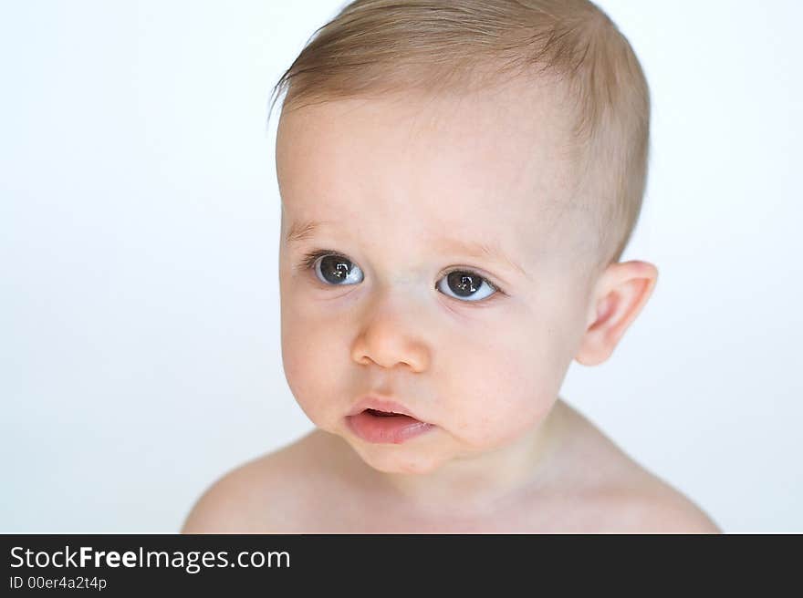 Image of beautiful 11 month old baby boy  sitting in front of a white background. Image of beautiful 11 month old baby boy  sitting in front of a white background