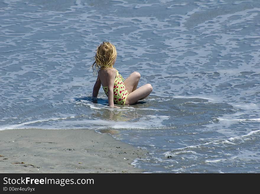 Young girl relaxing in the surf on a sunny day in Florida. Young girl relaxing in the surf on a sunny day in Florida