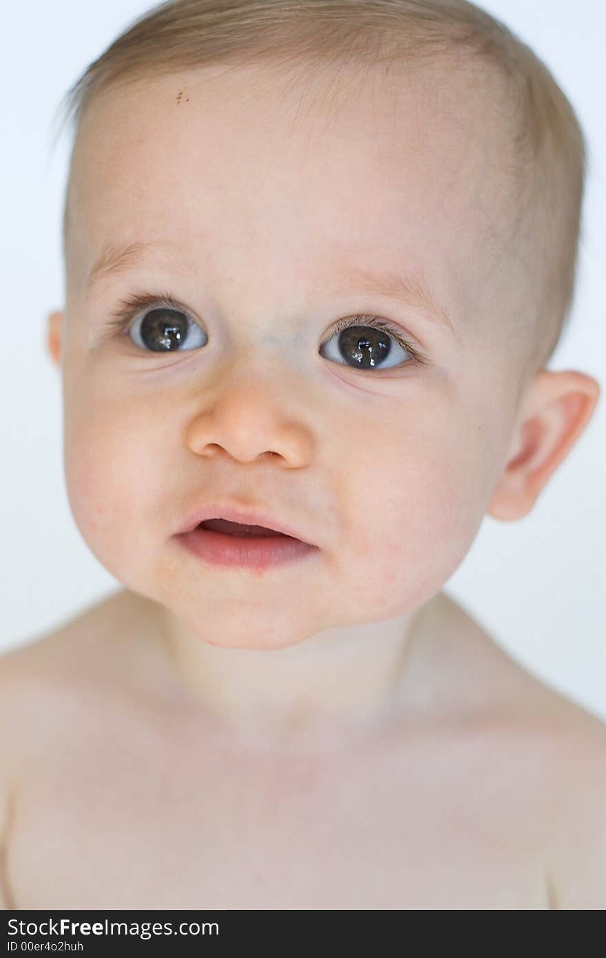 Image of beautiful 11 month old baby boy  sitting in front of a white background. Image of beautiful 11 month old baby boy  sitting in front of a white background