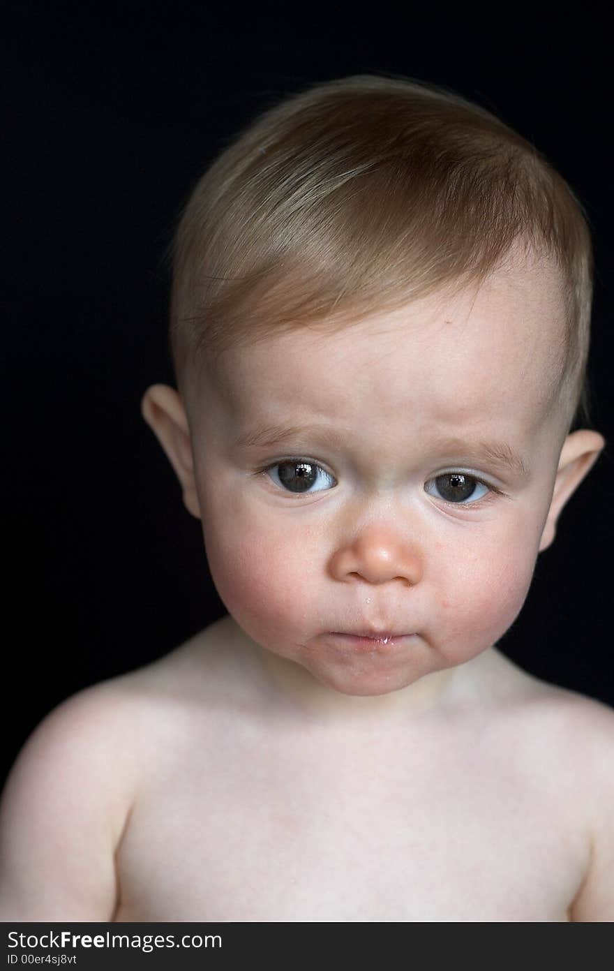 Image of beautiful baby sitting in front of a black background