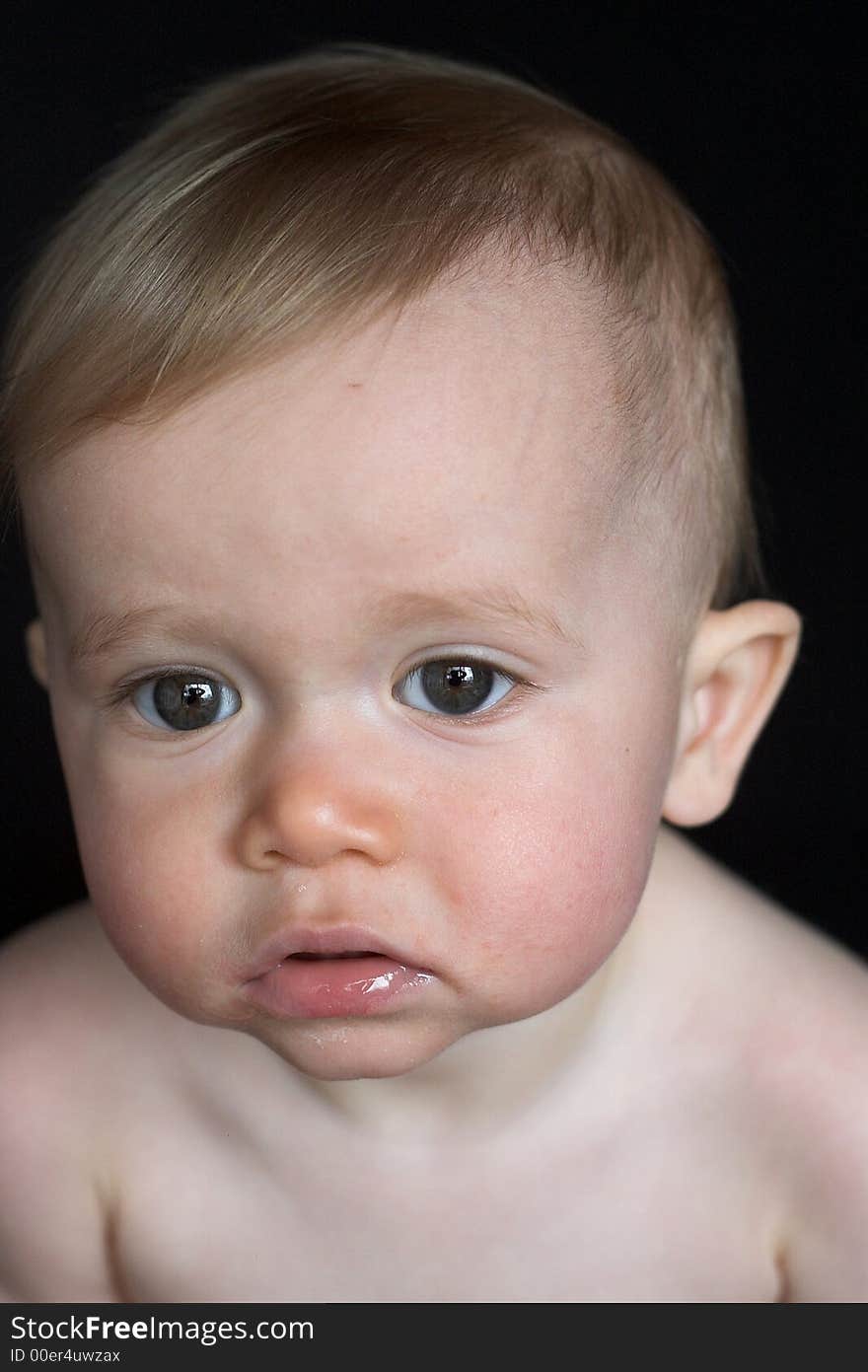 Image of beautiful baby sitting in front of a black background