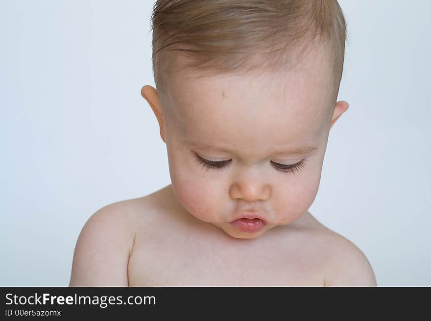 Image of beautiful 11 month old baby boy sitting in front of a white background. Image of beautiful 11 month old baby boy sitting in front of a white background