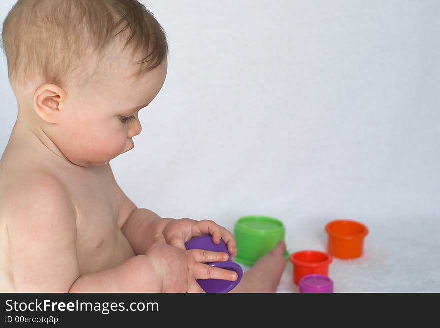 Image of adorable baby playing with stacking cups. Image of adorable baby playing with stacking cups