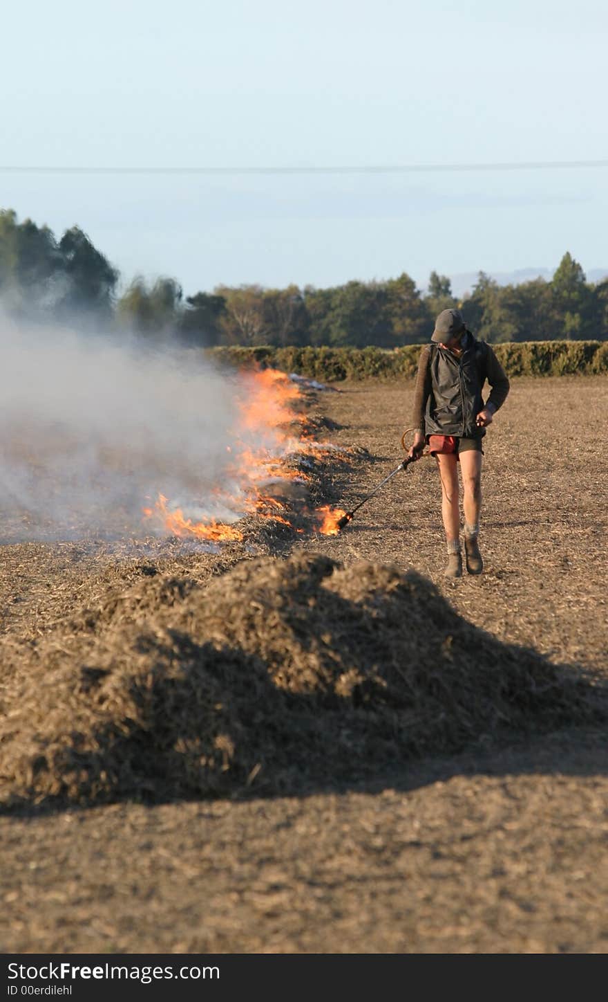 Farm hand lighting part of a Grass/Stubble fire on a paddock in Canterbury, New Zealand. Farm hand lighting part of a Grass/Stubble fire on a paddock in Canterbury, New Zealand.