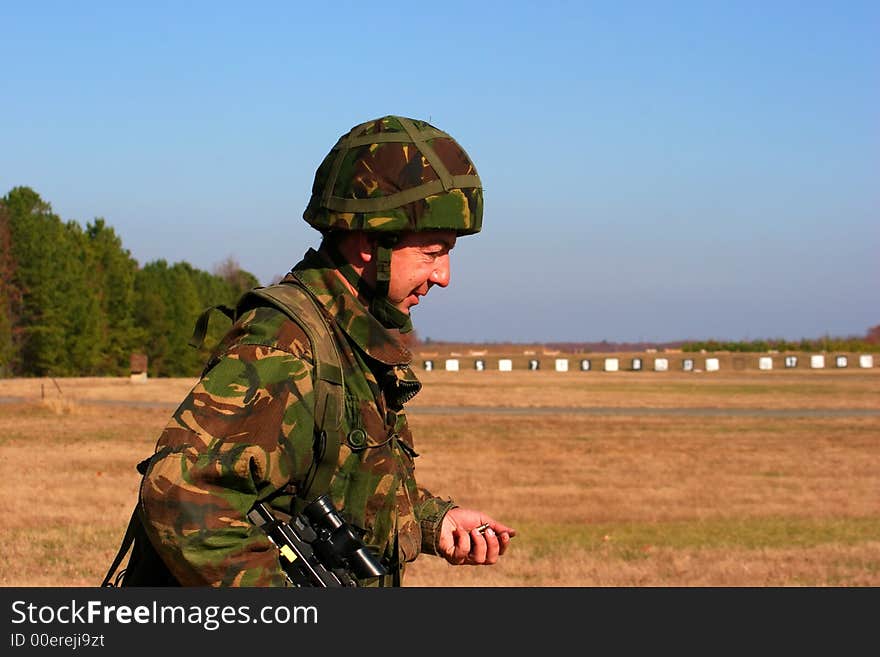 A sailor collects the brass on the range after a firing serial. A sailor collects the brass on the range after a firing serial