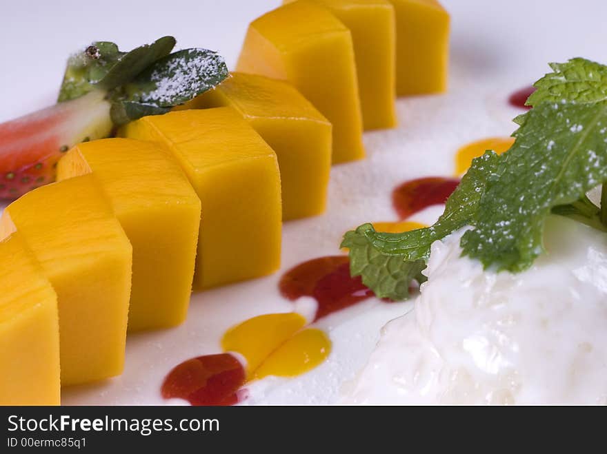 Color mango dessert decorated with strawberry and mint. Color mango dessert decorated with strawberry and mint